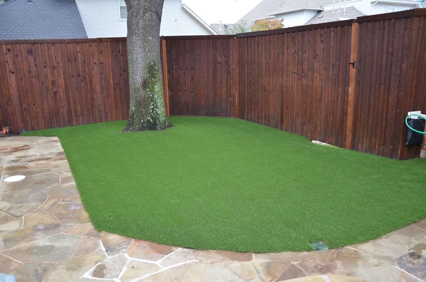 After: a fenced corner of a yard beside a flagstone patio