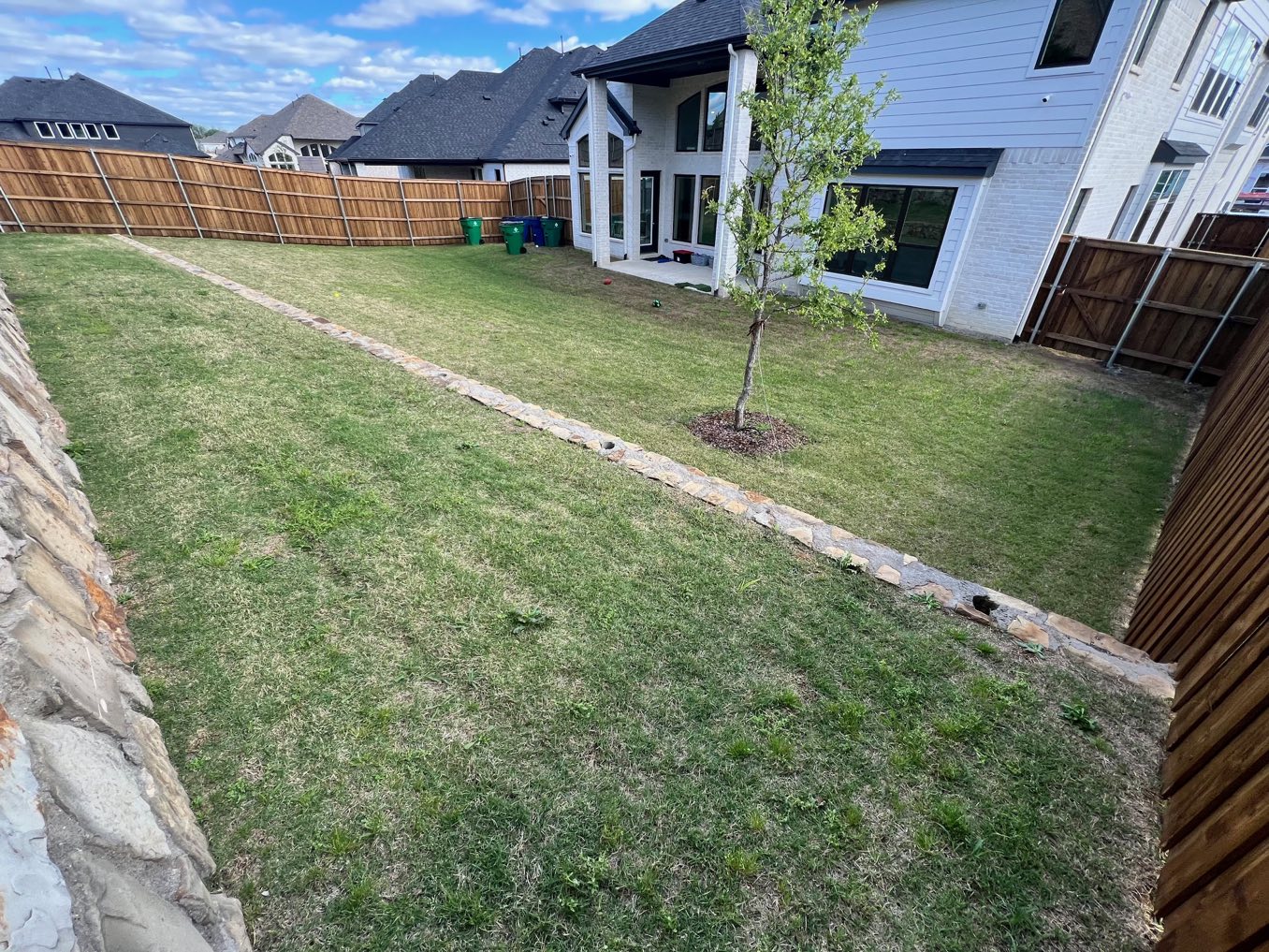 Before: a long, narrow backyard strip behind a two-story house