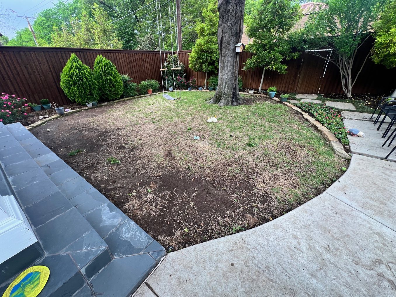 Before: a worn circular lawn between a patio and garden beds
