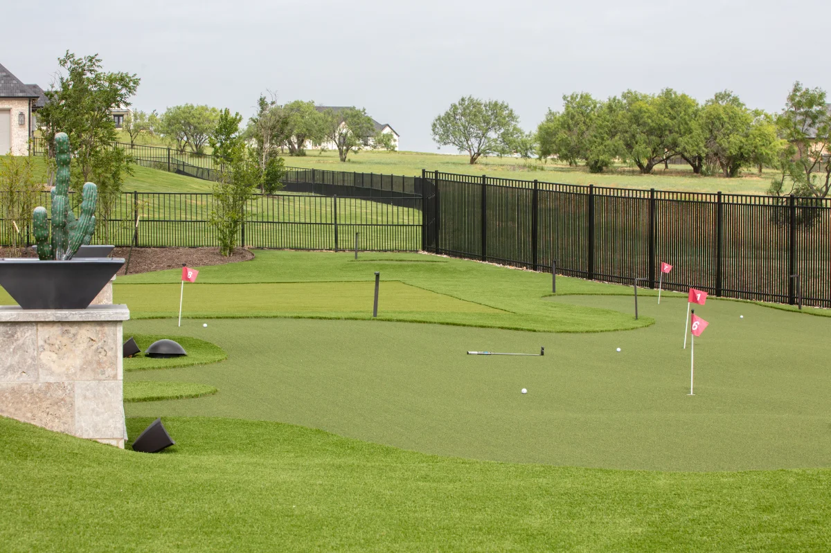 A wide graded lawn running level across a sloping lot