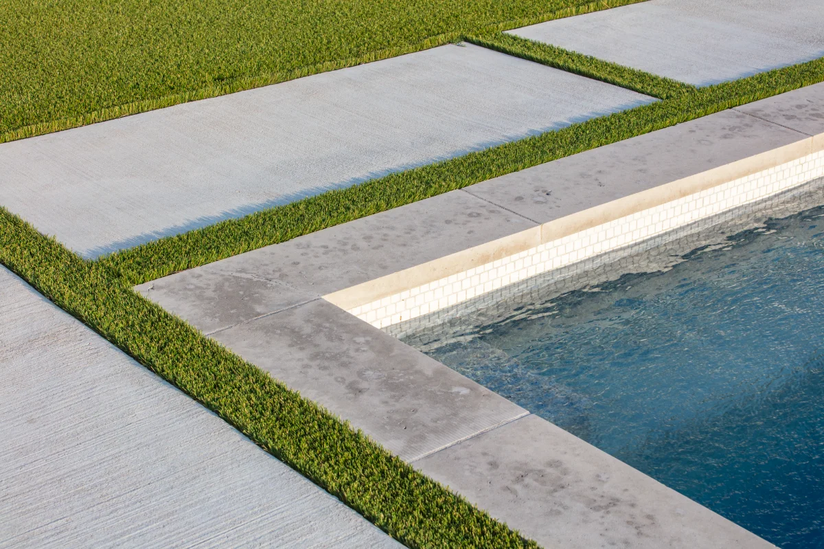 Close view of installed turf meeting a stone edge, showing pile height and colour